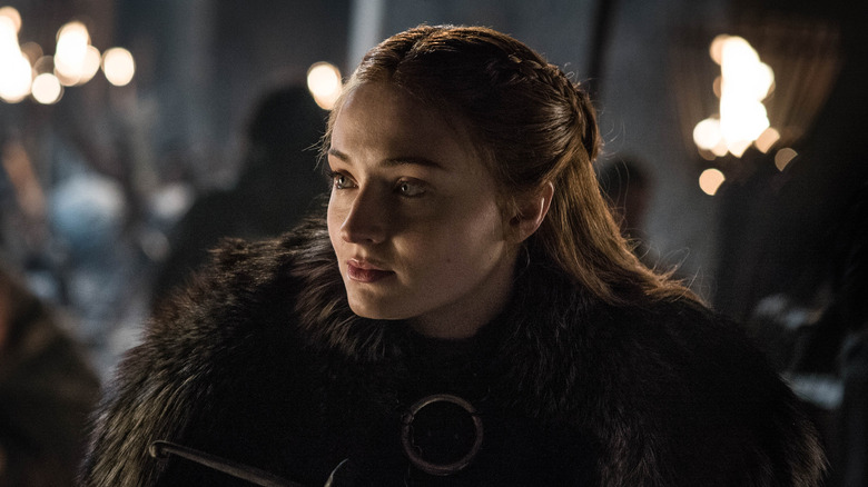 Sansa lit by torches in a fur coat on Game of Thrones