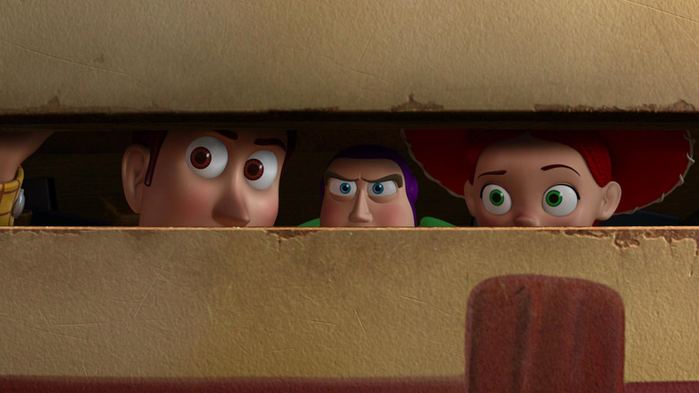 Woody, Buzz Lightyear, and Jessie peer out of the toy chest in Toy Story 3