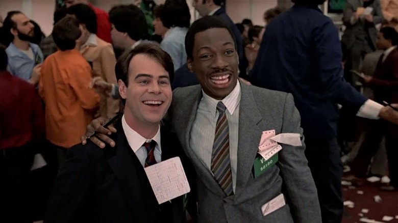 Winthorpe and Valentine smiling with papers stuffed in their pockets in Trading Places