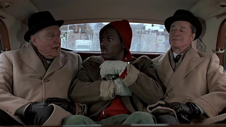 Valentine sitting in a car next to the Dukes in Trading Places