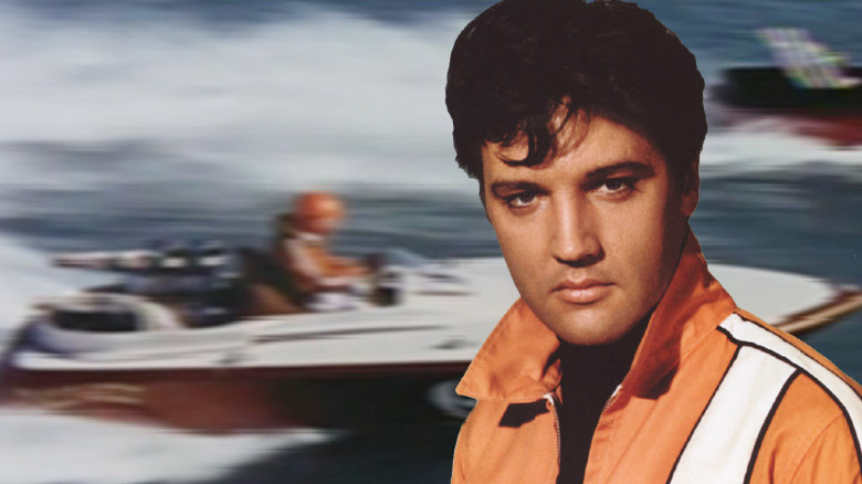 Elvis Presley standing in front of a boat in Clambake