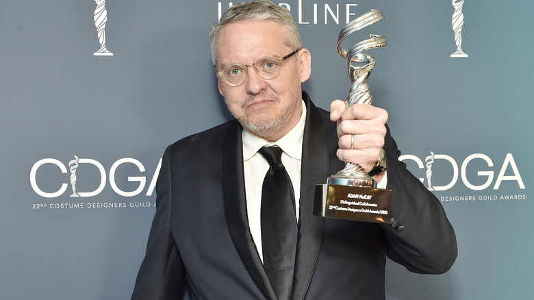 Adam McKay holds a trophy