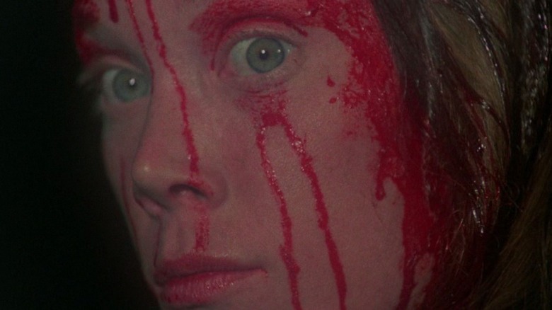 Carrie White, her face bloody, stares at the camera creepily in close-up