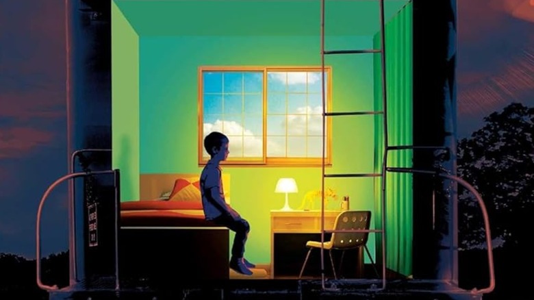 Luke sits in a small green room in the back of a train, from the book cover for The Institute