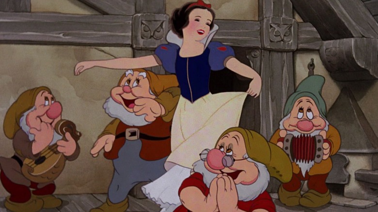 Snow White dancing with several merry-making dwarfs in Snow White and the Seven Dwarfs.