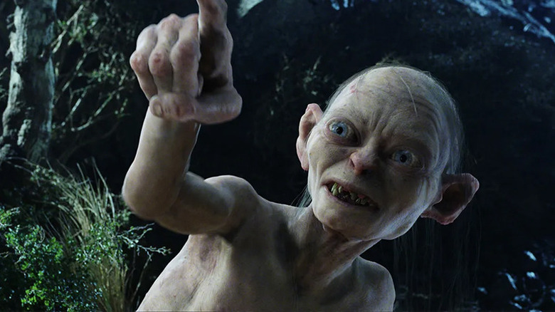 A moonlit Gollum pointing up at something off screen in The Lord of the Rings trilogy