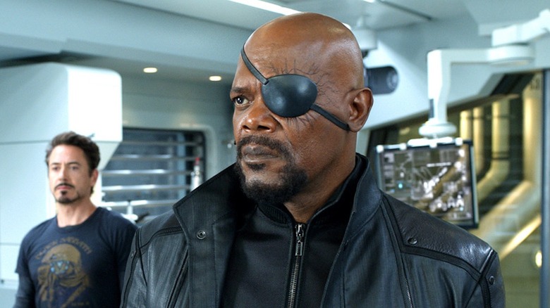 Samuel L. Jackson glowers as Nick Fury as Robert Downey Jr. as Tony Stark looks on in the background in The Avengers