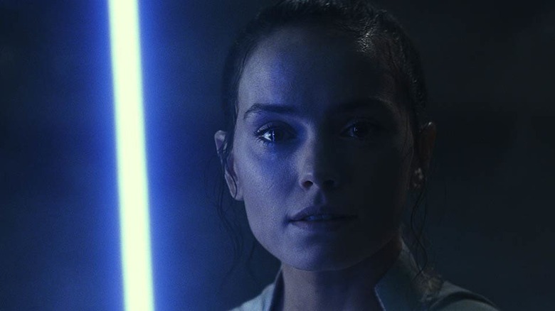 Rey ignites lightsaber in the shadows