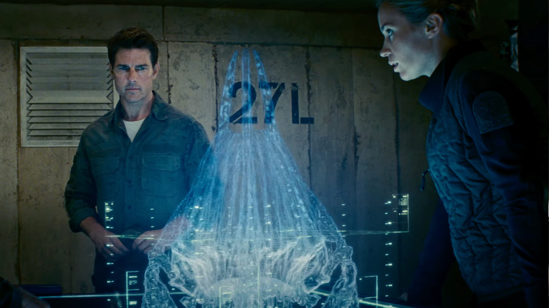 Cage and Rita stare at a hologram