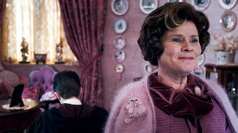 Umbridge tersenyum di kantornya sementara Harry menulis baris-baris di Harry Potter dan Orde Phoenix