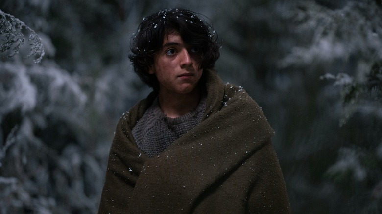 Javi wrapped in a blanket in the snow in Yellowjackets