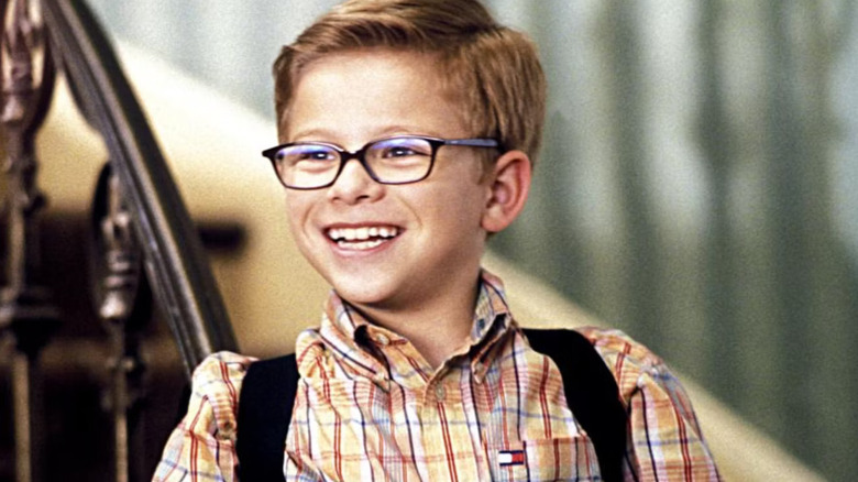 George, wearing a plaid collared shirt and a backpack, smiles widely in Stuart Little.