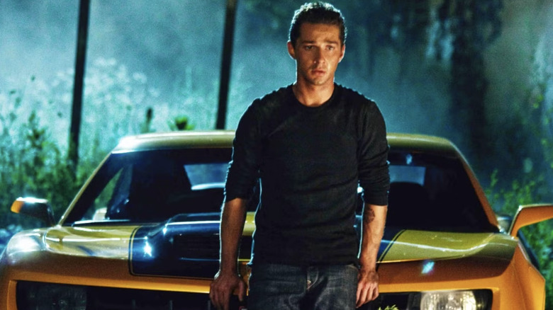 Sam Witwicky stands in front of Bumblebee in Transformers