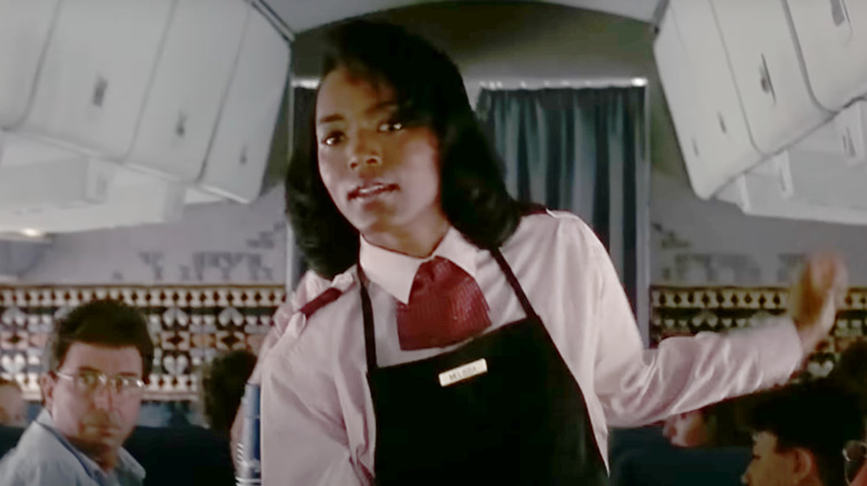 Angela Bassett as Stewardess walks through a plane in Kindergarten Cop