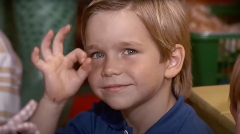 Joseph Cousins as Dominic gives the OK sign in Kindergarten Cop