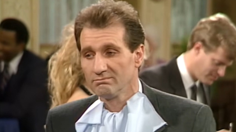 Ed O'Neill as Al Bundy looking grumpy at dinner on Married with Children