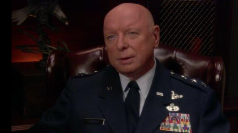 Don S. Davis' Hammond, in military attire, sitting in a chair in Stargate SG-1