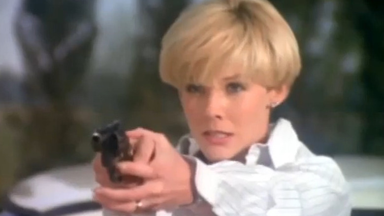 Kimberly Foster as Michelle Stevens, aiming a gun on Dallas