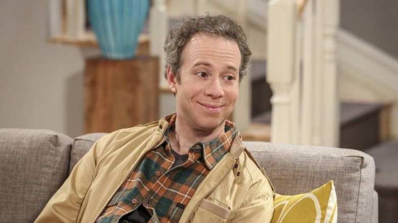 Stuart smiling on a couch on The Big Bang Theory