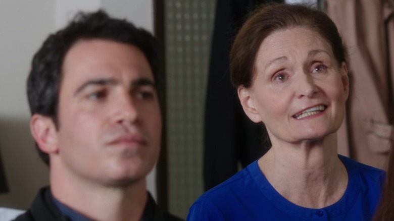 Beverly (Beth Grant) talking, with Dr. Danny (Chris Messina) in the foreground out of focus, on The Mindy Project