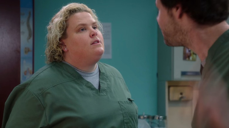 Collette (Fortune Feimster) in green scrubs, looking defiant, in The Mindy Project