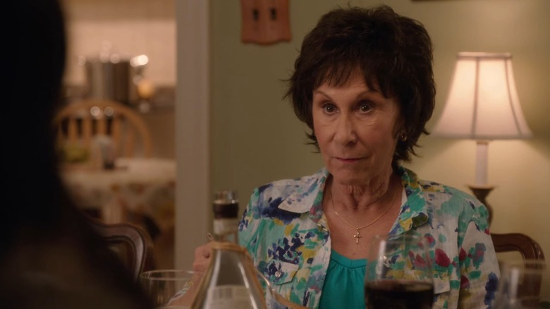 Annette (Rhea Perlman) in a floral print shirt, sitting at a dinner table, on The Mindy Project