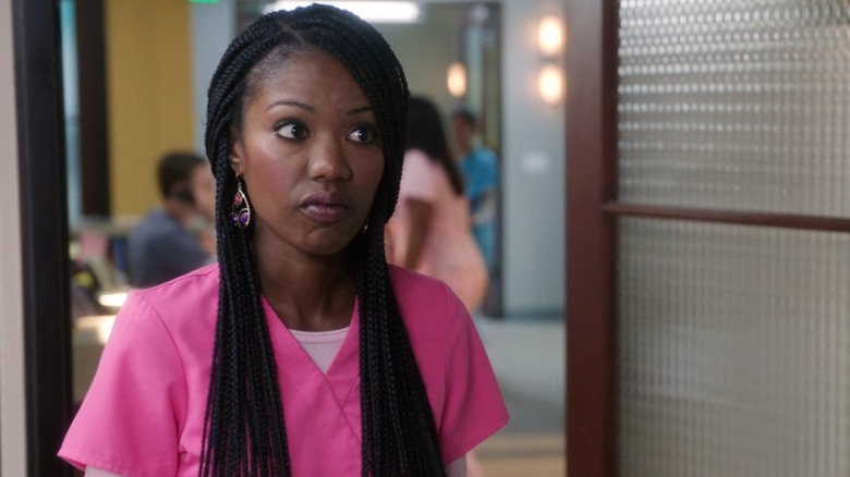 Tamra (Xosha Roquemore) in pink scrubs, looking skeptical, on The Mindy Project