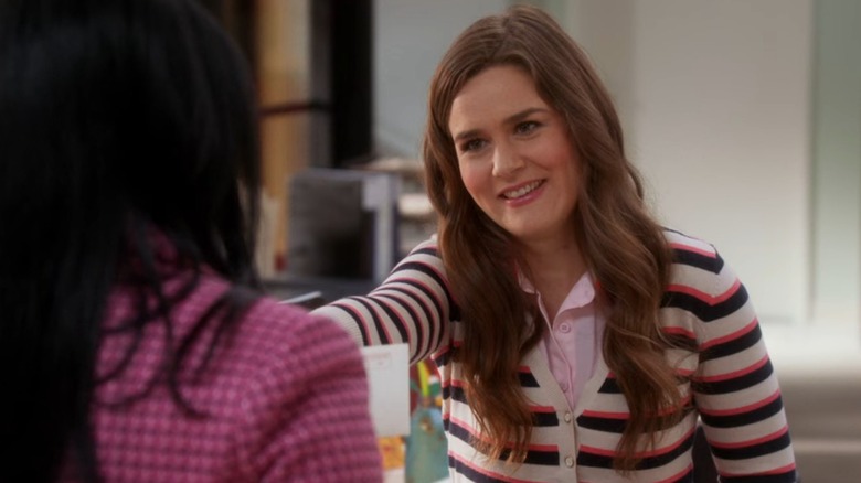 Betsy (Zoe Jarman) in a pink, black, and white striped shirt, smiling at Mindy, on The Mindy Project