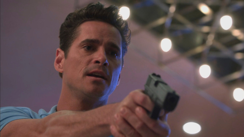 Seth Peterson as Nate Westen holding a gun in Burn Notice.