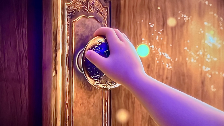 Young Mirabel grabs a doorknob in Encanto