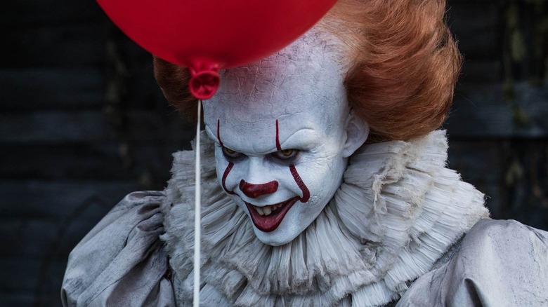 Pennywise smiling holding a balloon