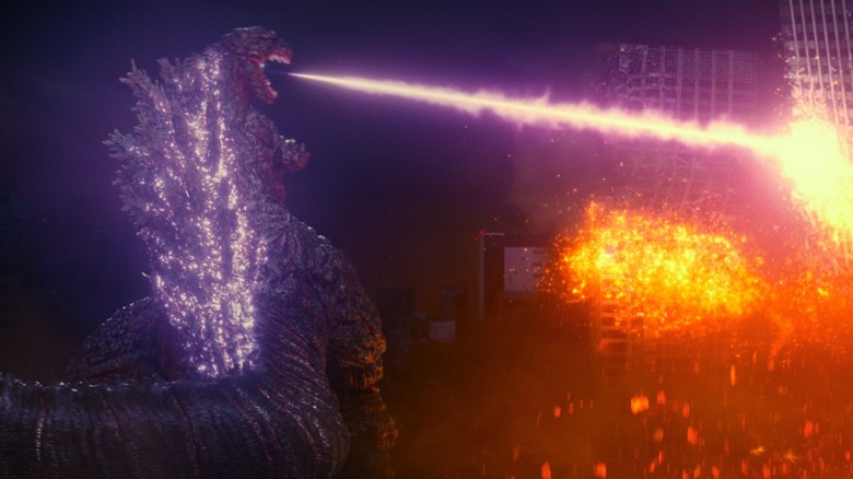 Godzilla blasting a building with his purple atomic fire breath