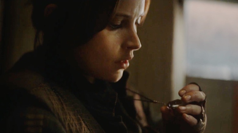 Jyn Erso examines the Kyber Necklace given to her by her mother