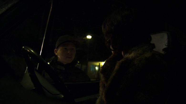 Under the Skin's Laura looking at man standing outside her car window at night