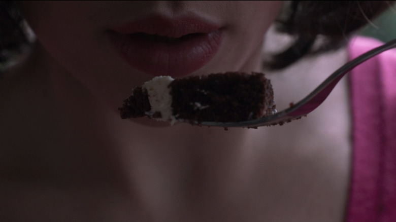 Close-up of Laura holding piece of cake to her mouth in Under the Skin