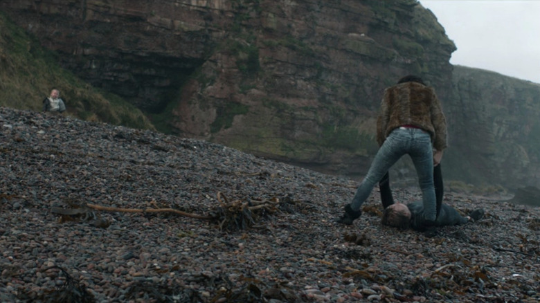 Under the Skin's Laura dragging a man down the beach with baby in background