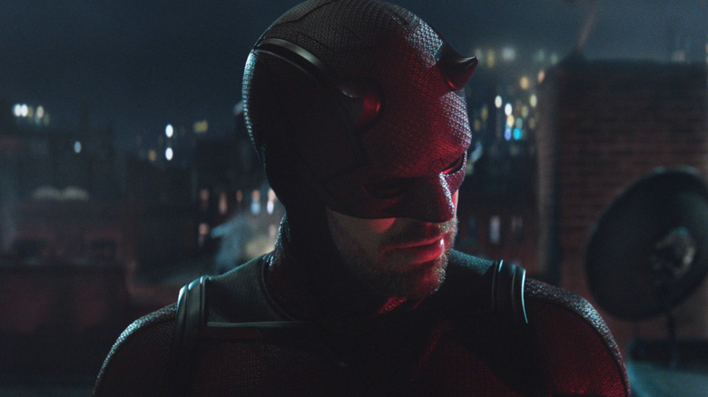 Charlie Cox's Daredevil cocking his head atop a building in Daredevil: Born Again