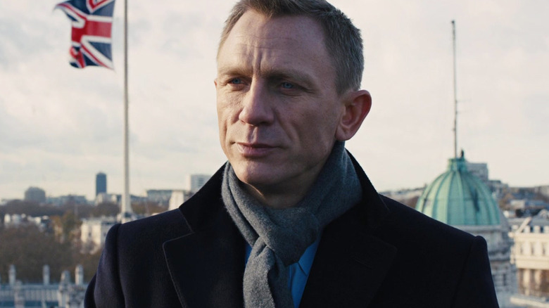 Daniel Craig's James Bond stands on a London rooftop with the Union Jack visible in the background in Skyfall