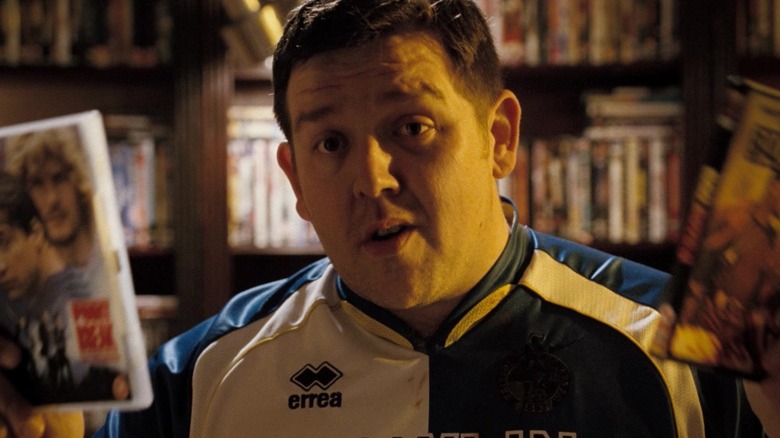 Danny Butterman holding Point Break and Bad Boys II in Hot Fuzz