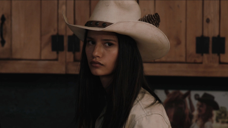 Avery está no barracão de Yellowstone usando um chapéu de cowboy branco e parecendo conflituosa.