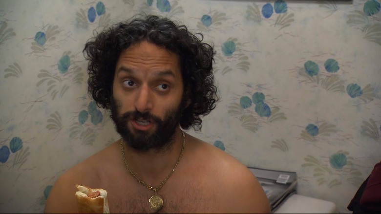 The League Rafi eats a hot dog in the bathroom