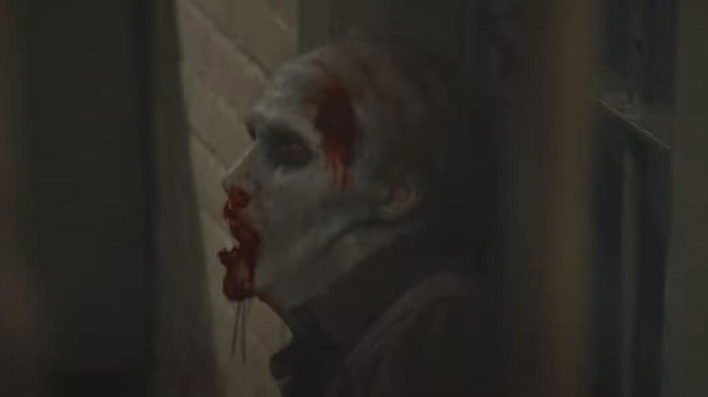 bleeding zombie leans against wall