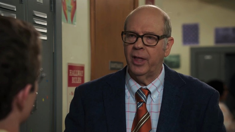 Stephen Tobolowsky as Principal Earl Ball talking in the hallway in The Goldbergs