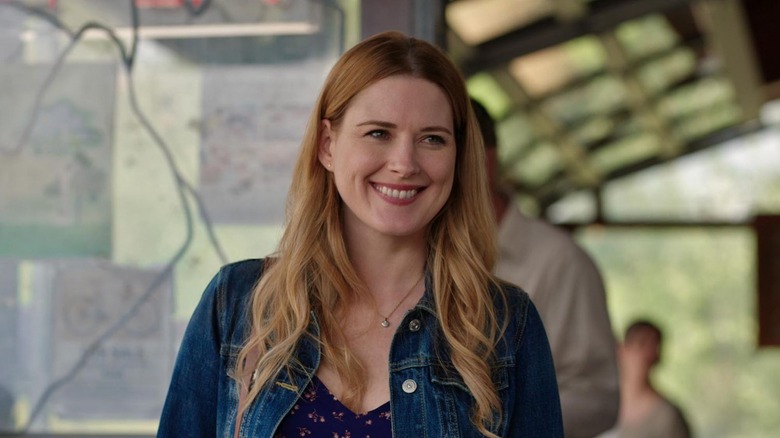 Mel Monroe (Alexandra Breckenridge) smiles at someone offscreen while standing in an exterior setting