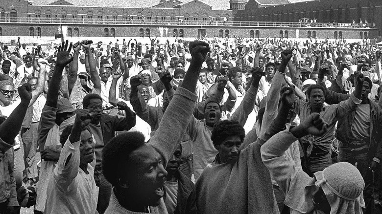 men of color stand with fists raised in a large group