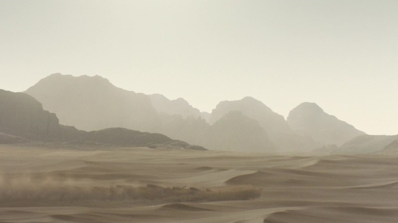 A trail of disturbed sand is thrown up into the air in a desert in Dune Part Two