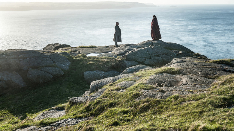 Varys and Melisandre standing on the rocks at Dragonstone in Game of Thrones