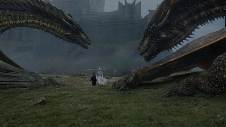 Tyrion and Daenerys walking towards two dragons at Dragonstone in Game of Thrones