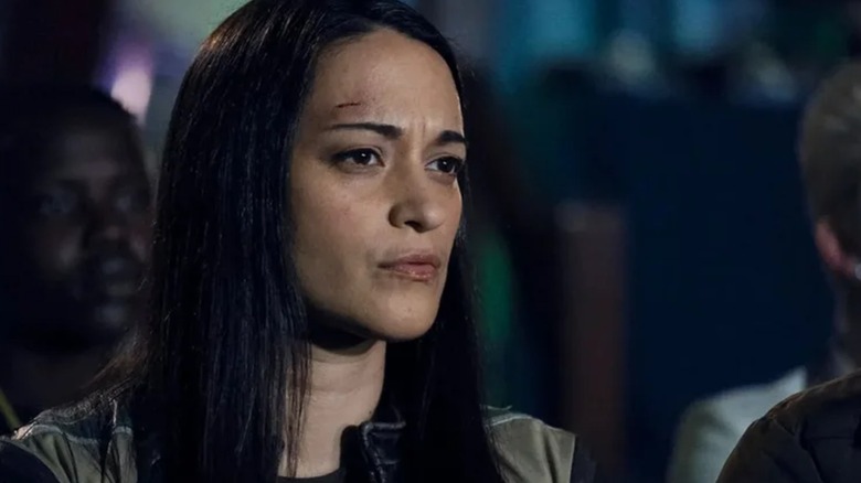 Sara Tomko's Asta stands in a group with a cut on her forehead in Resident Alien