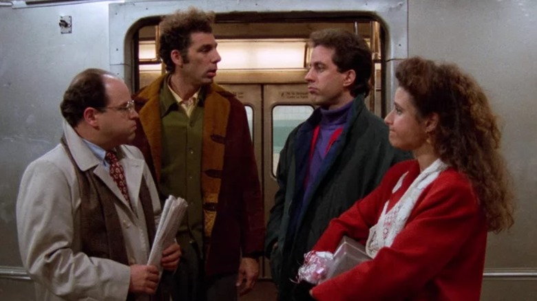 Jason Alexander's George and Michael Richards' Kramer look at Jerry Seinfeld's Jerry and Julia Louis-Dreyfus' Elaine while standing outside a subway car in Seinfeld